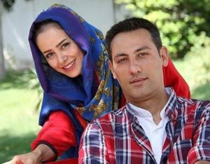عکس دو نفره الناز حبیبی با شال آبی و مانتو قرمز و همسرش با لباس چهارخانه