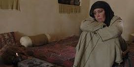 معصومه تقی پور در نقش طوعه -پناه دهنده مسلم بن عقیل چمباتمه زده در صحنه ای از فیلم