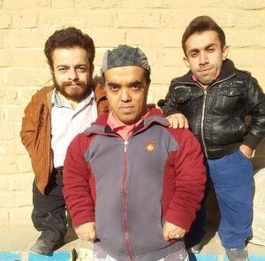 علی ابراهیمی بازیگر کوتاه قد سینمای ایران با کاپشن طوسی قرمز به همراه دوستانش