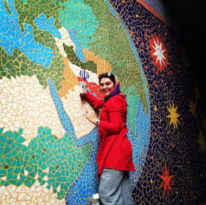 لاله اسکندری با مانتو قرمز در حال کاشی کاری معروف در یکی از خیابان های تهران