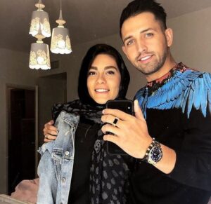 محسن افشانی با لباس اسپرت مشکی و همسرش
