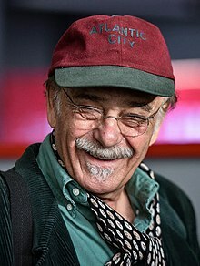 عکسی از رضا بابک با کلاه و پیراهن سبز و شال گردن