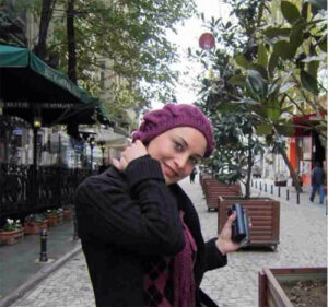 عکس مریم کاویانی با لباس مشکی و شال و کلاه بنفش در خارج از کشور