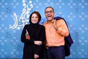 رامبد جوان با پیراهن نارنجی در کنار همسرش در جشنواره فیلم فجر