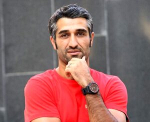 پژمان جمشیدی با تیشرت قرمز از بازیگران مرد قد بلند ایرانی