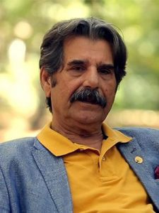 عزت‌الله مهرآوران با تیشرت زرد از بازیگران مرد ایرانی بالای 40 سال